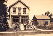 Sepia-toned photo of family in front of two-story house