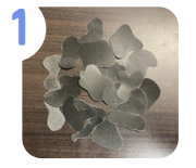 Labeled "one." A photo of a pile of abstract shapes cut out from black paper.