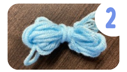 Labeled "two." A small bundle of blue yarn tied in the middle.