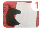 Labeled "one." A cut out template of a horse head silhouette next to a tracing of the template in pencil on white paper.