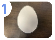 Labeled "one." An egg cut out of white paper.